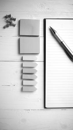 notepad with office supplies on white table view from above black and white tone color styleの写真素材