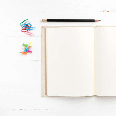 notebook with office supplies over white tableの写真素材