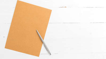 brown paper with pen on white table view from aboveの写真素材