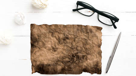 burning brown paper and crumpled paper over white tableの写真素材