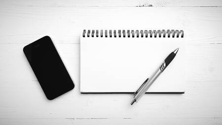 notepad and cellphone over white table black and white color tone styleの写真素材