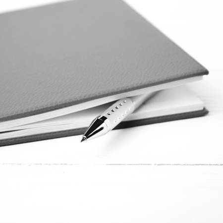 notebook and pen over white table black and white tone color styleの写真素材