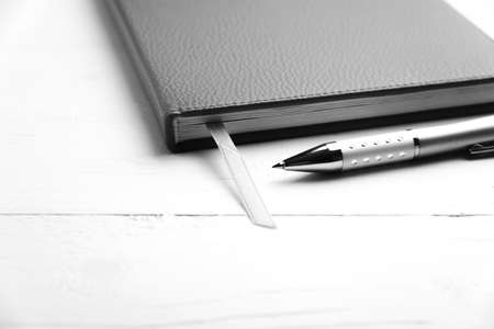 notebook and pen over white table black and white tone color styleの写真素材