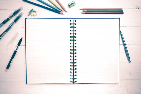 notepad with office supplies on white table view from above vintage styleの写真素材