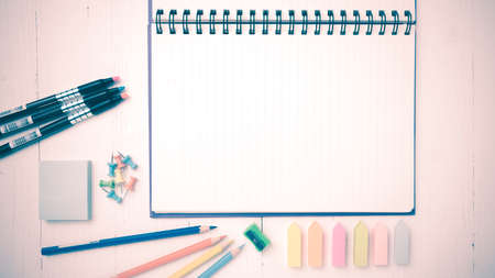 notepad with office supplies on white table view from above vintage styleの写真素材