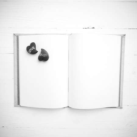 heart on notebook over white table black and white tone color styleの写真素材