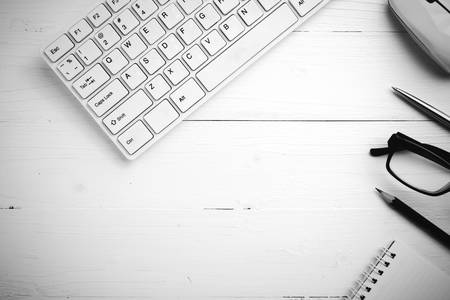 computer and notepad with pen on white table black and white styleの写真素材