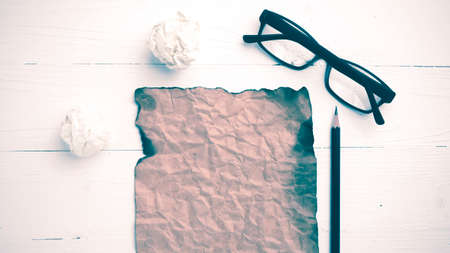 burning brown paper and crumpled paper over white table vintage styleの写真素材