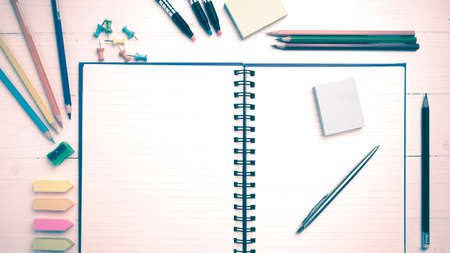 notepad with office supplies on white table view from above vintage styleの写真素材