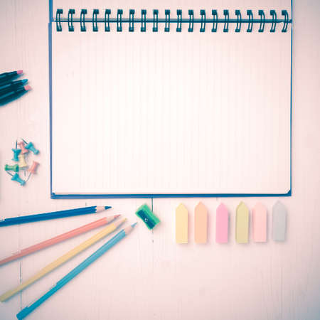 notepad with office supplies on white table view from above vintage styleの写真素材