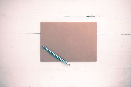 brown paper with pen on white table view from above vintage styleの写真素材