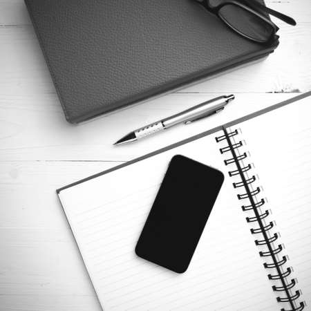 notepad with stack of book on table view from above black and white tone color styleの写真素材
