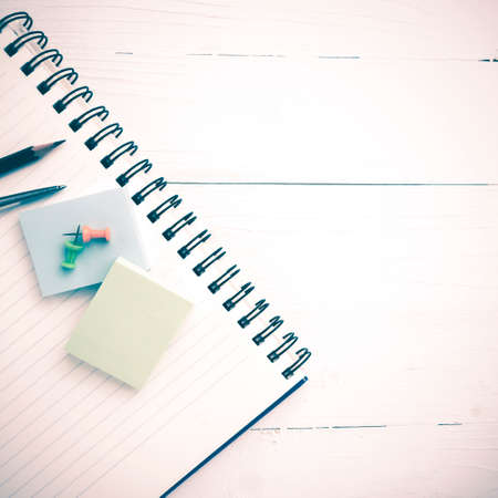 notepad with office supplies on white table view from above vintage styleの写真素材