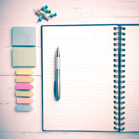 notepad with office supplies on white table view from above vintage styleの写真素材