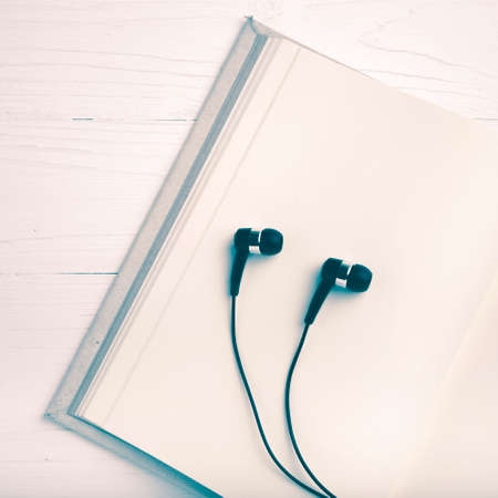 notebook and ear phone over white table vintage styleの写真素材