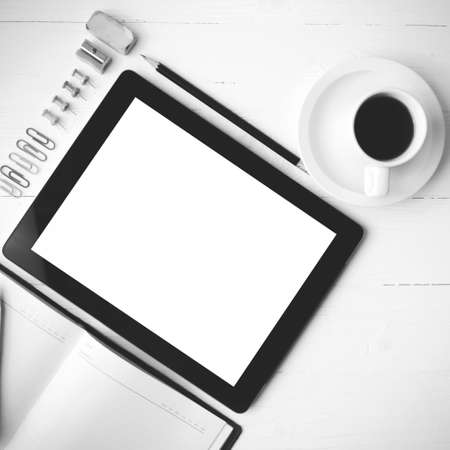 tablet with notebook and coffee cup over white table black and white color styleの写真素材