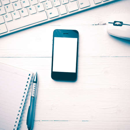 cellphone with computer and coffee cup over white table vintage styleの写真素材