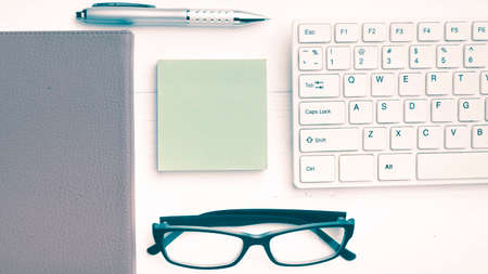 computer and sticky note over office table vintage styleの写真素材