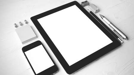 tablet and cellphone with office supplies over white table black and white color styleの写真素材