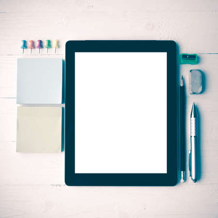 tablet with office supplies over white table vintage styleの写真素材
