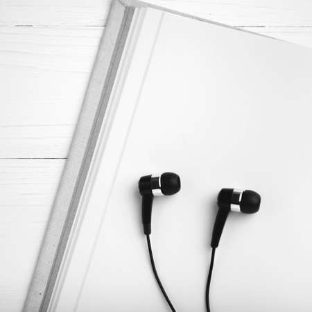 notebook and ear phone over white table black and white color styleの写真素材