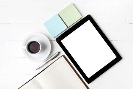 tablet with notebook and coffee cup over white tableの写真素材