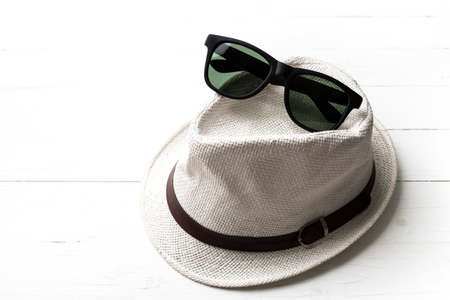 hat and sunglasses on white tableの写真素材