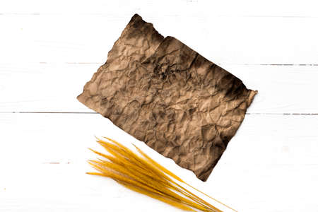 old brown paper and wheat on white tableの写真素材