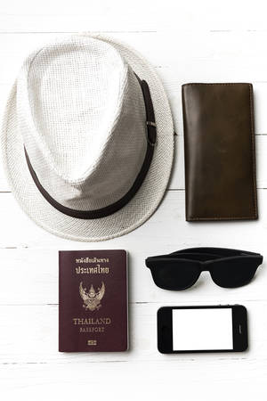 hat sunglasses smart phone and passport over white tableの写真素材