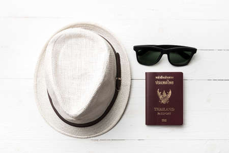 hat sunglasses and passport on white tableの写真素材
