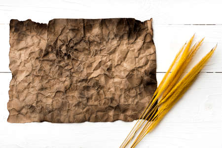 old brown paper and wheat on white tableの写真素材