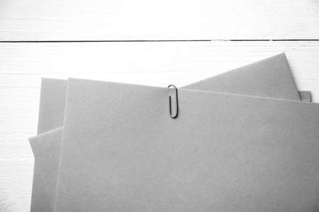 brown paper with green paper clip over white table black and white color