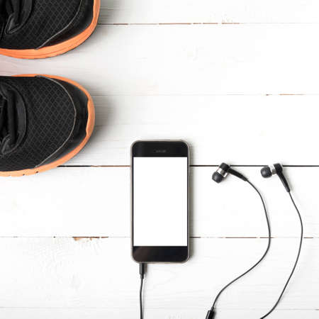 running shoes and phone on white wood tableの写真素材