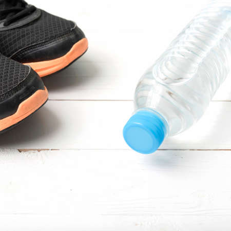 running shoes and drinking water on white tableの写真素材