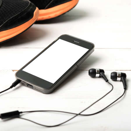 running shoes and phone on white wood tableの写真素材