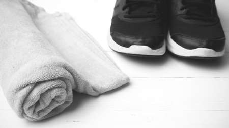 running shoes and towel on white wood table black and white tone color styleの写真素材