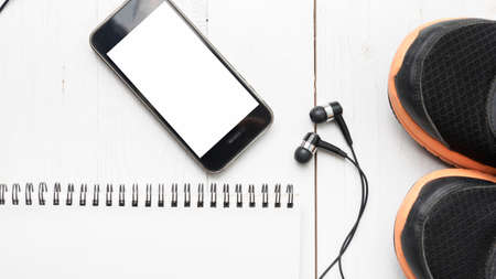 running shoes,notebook and phone on white wood tableの写真素材