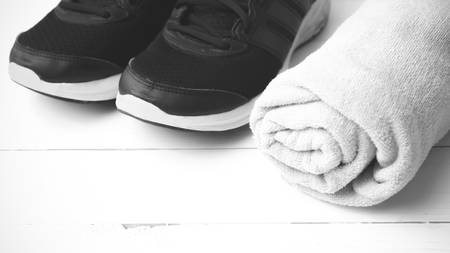 running shoes and towel on white wood table black and white tone color styleの写真素材