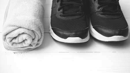 running shoes and towel on white wood table black and white tone color style