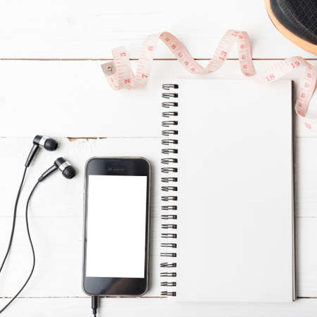 running shoes,measuring tape,notebook and phone on white wood tableの写真素材