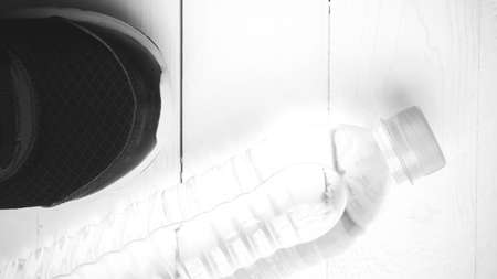 running shoes and drinking water on white table black and white tone color styleの写真素材