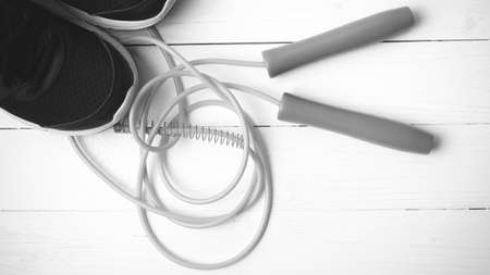 running shoes and jumping rope on white table black and white tone color styleの写真素材