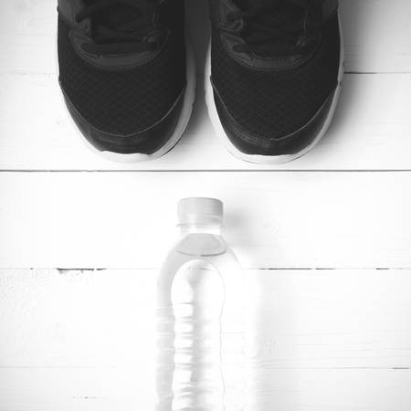 running shoes and drinking water on white table black and white tone color styleの写真素材