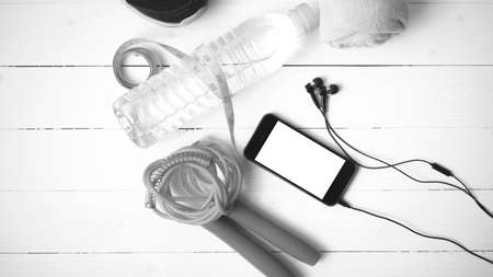 fitness equipment : running shoes,towel,jumping rope,water bottle,phone and measuring tape on white...