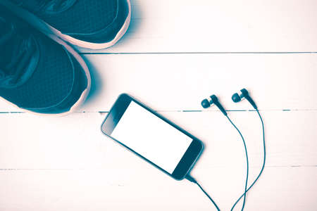 running shoes and phone on white wood table vintage styleの写真素材