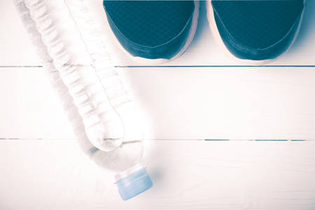 running shoes and drinking water on white table vintage style