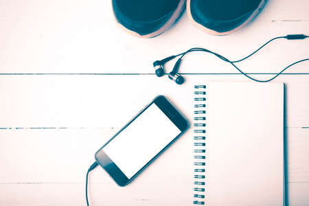 running shoes,notebook and phone on white wood table vintage styleの写真素材