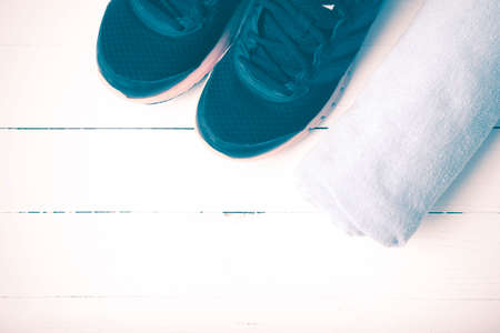 running shoes and towel on white wood table vintage styleの写真素材