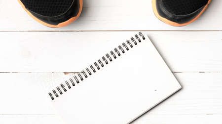 running shoes and notepad on white wood tableの写真素材