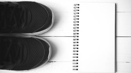 running shoes and notepad on white wood table black and white tone color styleの写真素材